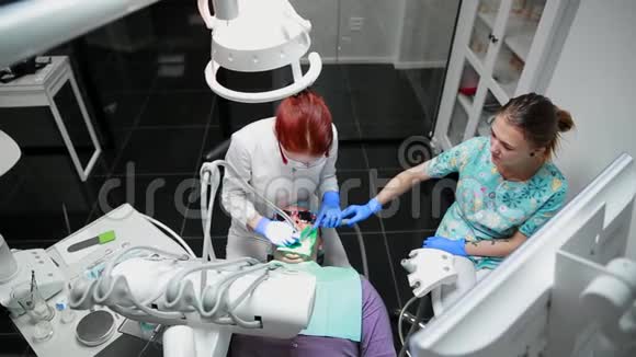 牙医和护士修理病人的牙齿用子钻牙去除蛀牙视频的预览图