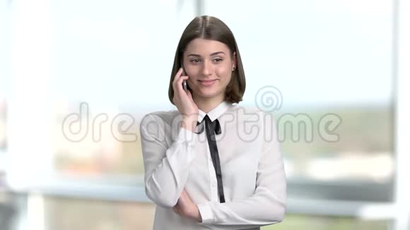 年轻微笑的女人在电话里说话视频的预览图