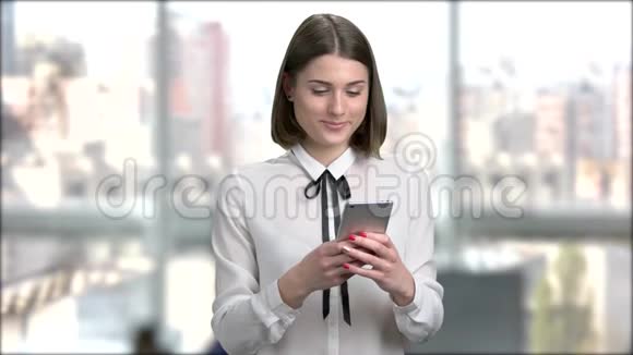 带着智能手机的漂亮微笑的女人视频的预览图