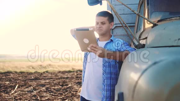 智慧农业生活方式男子农民司机站在卡车附近的数字平板电脑慢动作视频肖像视频的预览图