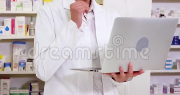 药剂师在药房使用笔记本电脑视频的预览图