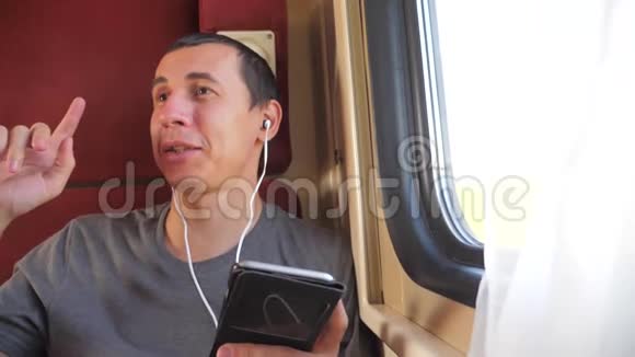 男子听着火车车厢车厢车厢车厢上的音乐旅行生活方式慢动作视频一个男人视频的预览图