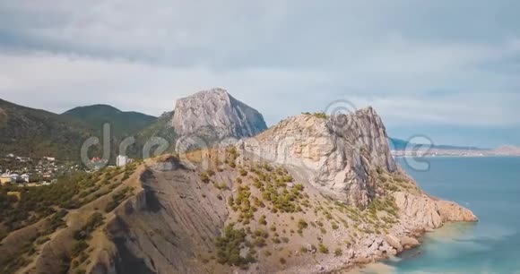 高山峰和大海山谷边缘的史诗岩石和太阳耀斑无人驾驶飞机飞行空中飞行视频的预览图