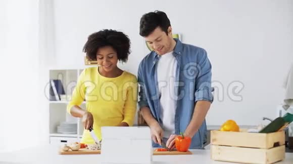 快乐的一对夫妇带着平板电脑在家做饭视频的预览图