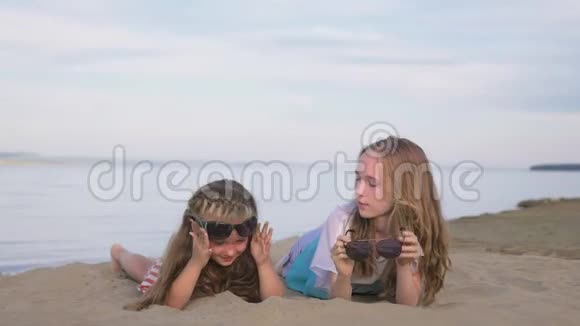 两个十几岁的孩子坐在海滩上视频的预览图