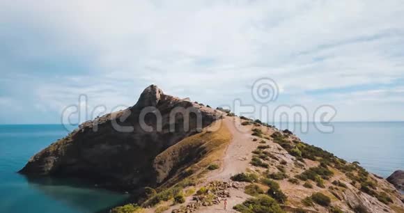 高山峰和大海山谷边缘的史诗岩石和太阳耀斑无人驾驶飞机飞行空中飞行视频的预览图