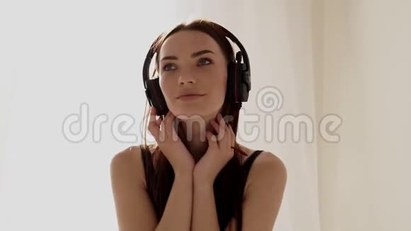 戴着大耳机在卧室听音乐的女孩视频的预览图