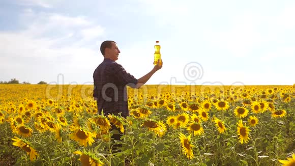 日落时分农夫手捧一瓶葵花籽油慢动作视频生活方式农民农业视频的预览图