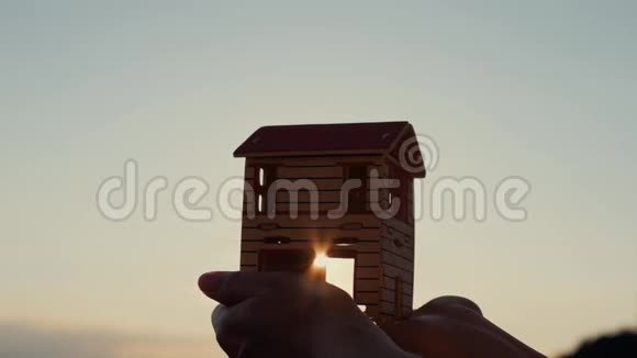 太阳落山时手里拿着纸房子的剪影视频的预览图