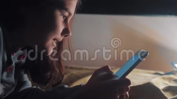 少女和智能手机小青少年帽女孩在社交生活方式媒体信使之夜的聊天留言视频的预览图