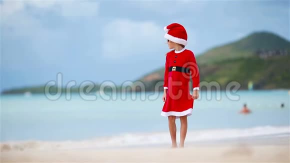 圣诞假期在白色海滩戴圣诞帽的可爱女孩视频的预览图