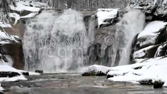 冬季瀑布小池塘和白雪皑皑的巨石瀑布层层叠叠山河的水晶冻水和声音视频的预览图