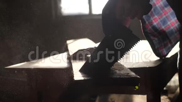 匠心手工与工艺概念慢动作视频木工在车间里锯树从一个车间里锯阳光视频的预览图