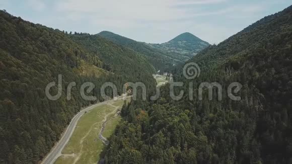 空中观车骑在路上的针叶林中的群山罗马尼亚夏季的公路旅行视频的预览图