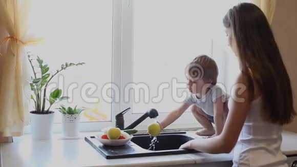 母亲和儿子在厨房洗蔬菜视频的预览图