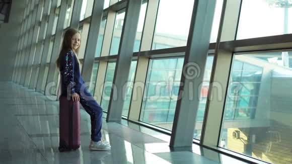 可爱的小女孩在机场拿着行李等待登机视频的预览图
