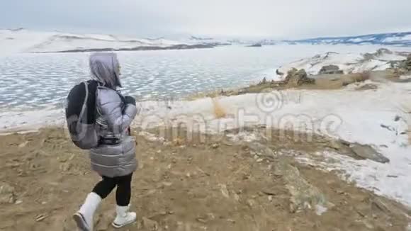 贝加尔湖冰上女子旅行佛教佛塔伯汗纪念塔象征神秘的历史仪式视频的预览图