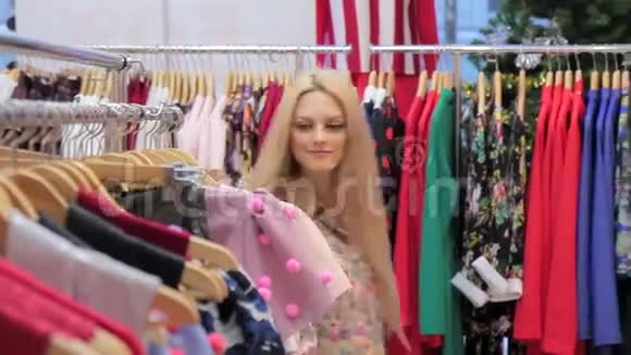 年轻的成年人心情愉快的女孩在服装店购物视频的预览图