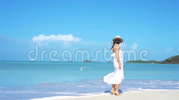 沙滩上戴帽子的年轻时尚女性视频的预览图