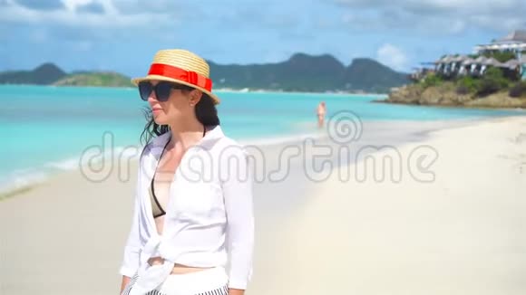 沙滩上戴帽子的年轻时尚女性视频的预览图