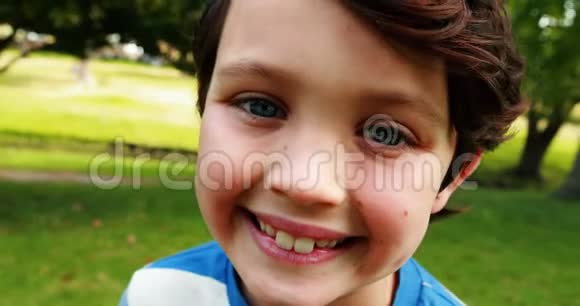 公园里微笑男孩的肖像视频的预览图