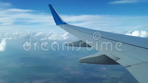 从窗外的飞机上看到翅膀和白云云层之间的飞行视频的预览图