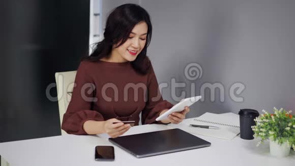 使用数码平板电脑及信用卡进行网上购物的妇女视频的预览图