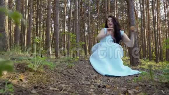 在森林里穿着蓝色裙子的漂亮女人视频的预览图