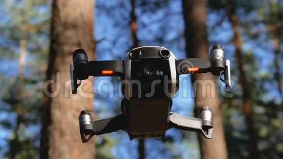 带着摄像机的无人机在空中盘旋四架直升机飞越森林的地面视频的预览图
