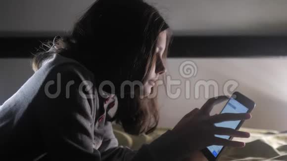 少女和生活方式智能手机一个小少女在社交媒体信使之夜写了一条聊天信息视频的预览图