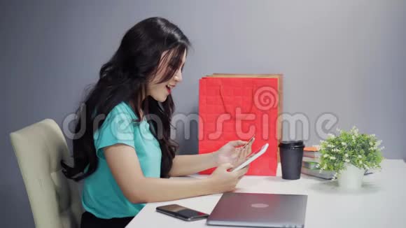 使用数码平板电脑及信用卡进行网上购物的妇女视频的预览图