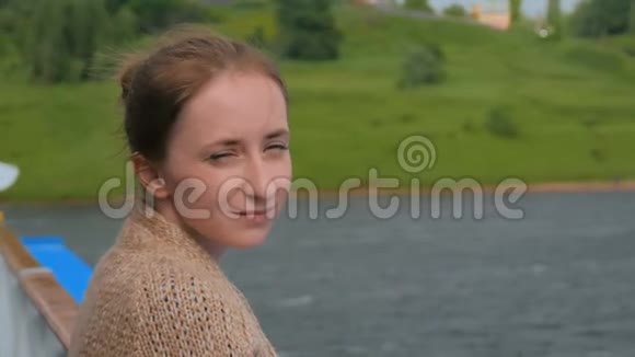 年轻女子站在游轮甲板上看着河流和风景视频的预览图