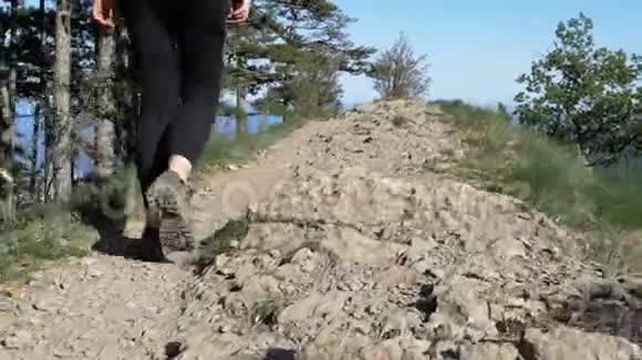 站在旅客的脚上妇女徒步行走在山顶悬崖在岩石上行走视频的预览图