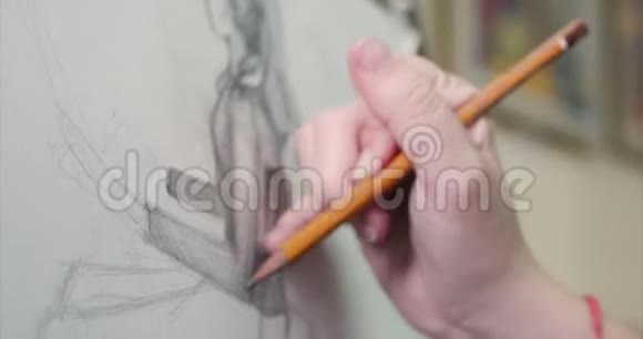 年轻美丽的女艺术家在一个艺术工作室坐在一个Easel后面和画布上的绘画绘图过程视频的预览图