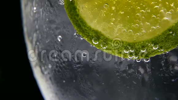 排毒或消渴的概念健康膳食营养冷柠檬水石灰饮料黑色背景视频的预览图