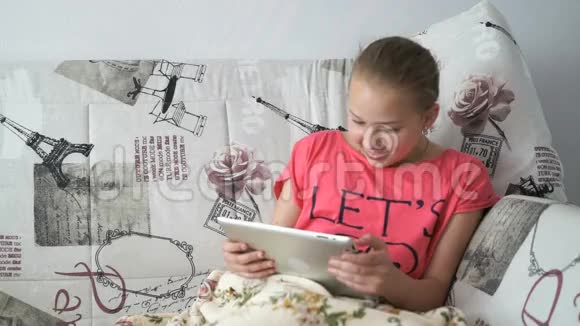 躺在床上的小女孩拿着数码平板电脑视频的预览图