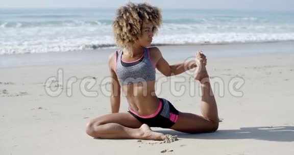 在沙滩上做瑜伽姿势的女人视频的预览图