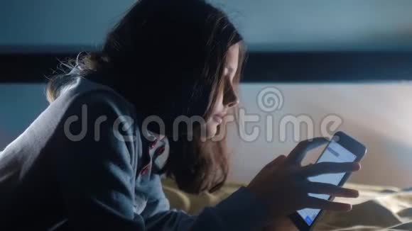 少女和智能手机生活方式小少女风帽女孩在社交媒体信使之夜留言聊天视频的预览图