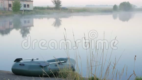 雾中湖面上的充气船一大早视频的预览图