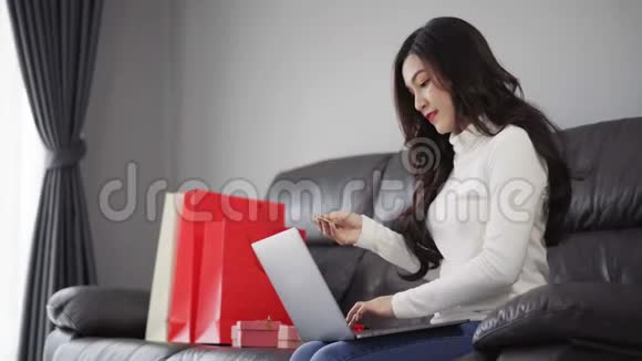 女士在网上购物礼品带笔记本电脑客厅视频的预览图