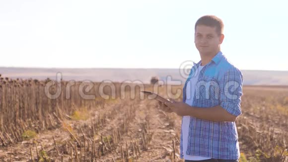 农民聪明的农业工人阅读或分析收获向日葵一种生活方式报告平板电脑上的农业视频的预览图
