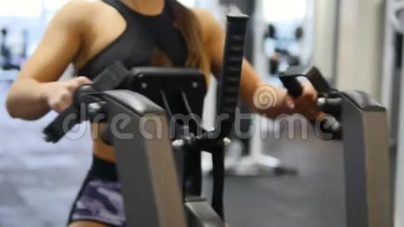 女子在健身房的模拟器上训练手臂和肩膀视频的预览图