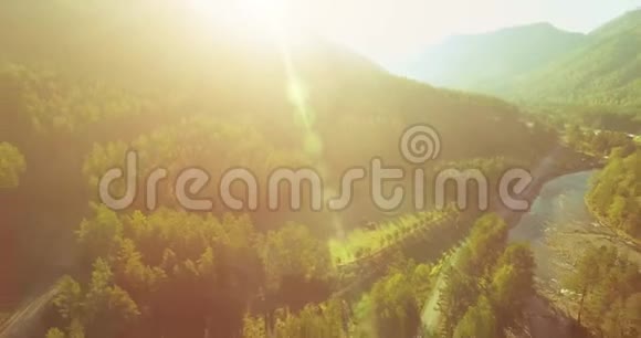 在阳光明媚的夏日早晨中气飞越新鲜的山河和草地农村土路下面视频的预览图