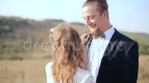 在草地上相爱的幸福夫妻肖像情侣温柔的爱情视频的预览图