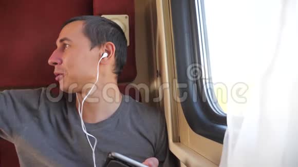 男子听音乐乘坐火车轨道生活方式汽车轿跑车厢旅行慢动作视频一个男人视频的预览图
