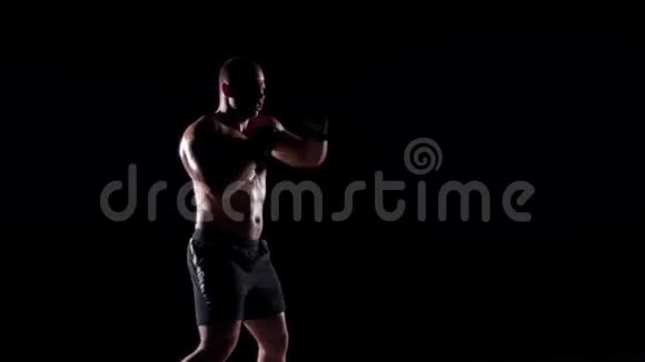 拳击手在黑色背景下训练影子拳击视频的预览图