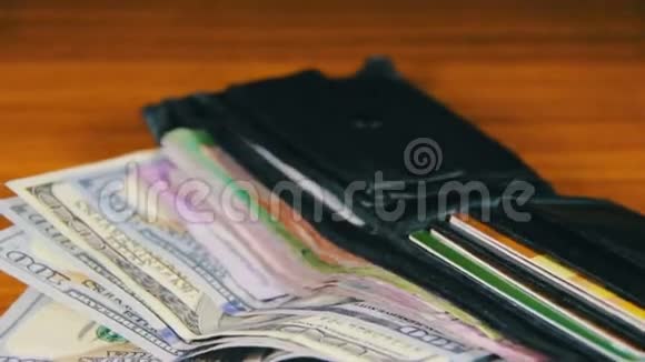 在木桌上旋转的钱包里的钱视频的预览图