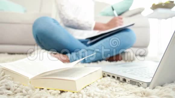 坐在地板上写记事本的女人视频的预览图