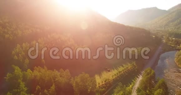 在阳光明媚的夏日早晨中气飞越新鲜的山河和草地农村土路下面视频的预览图