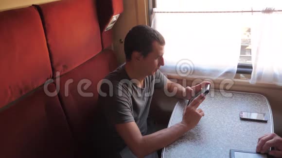 休闲男子从手机屏幕上阅读同时阅读生活方式短信在火车旅行慢动作视频的预览图